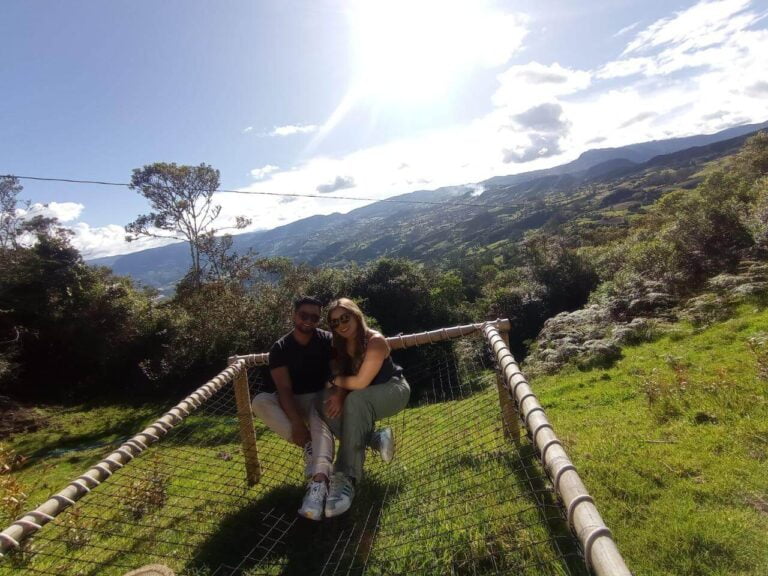 Dos personas caminando por un puente colgante en medio de un hermoso paisaje montañoso mientras disfrutan de su retiro de glamping en pareja.