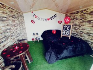 Interior acogedor de una cabaña de glamping con detalles románticos como corazones y un mensaje de amor, ideal para parejas que buscan planes románticos cerca a Bogotá.